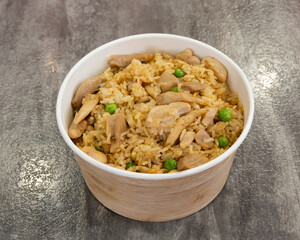 Chicken fried rice with peas served in a white cardboard container