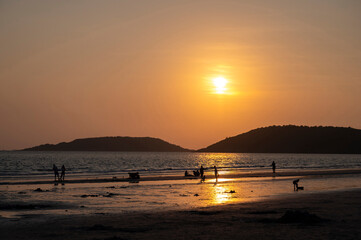 Silhouette photos are many people on the beach at sunset.