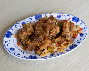 Braised chicken with sautéed vegetables served on a decorative blue plate for traditional home-cooked meal visuals
