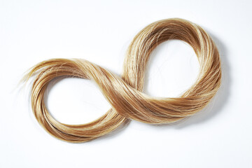 Blonde Hair Strand Arranged In Infinity Symbol On White Background