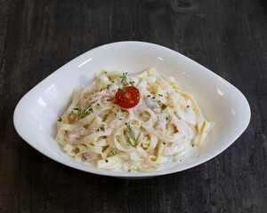 Spaghetti carbonara with raw egg yolk and parmesan in modern white bowl for traditional Italian food visuals