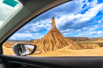 Discovering bardenas reales natural park from car window, unique rock formation under cloudy sky
