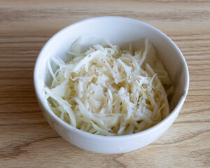 Shredded raw white cabbage in bowl for healthy ingredient or salad concept visuals