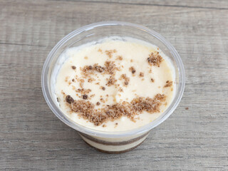 Classic tiramisu in individual glass cup with cocoa topping for traditional dessert visuals