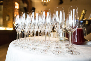A beautiful row of elegant wine glasses are meticulously lined up and displayed on a polished table, ready for the occasion