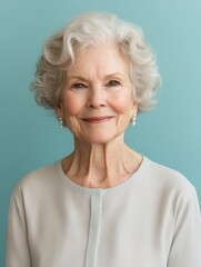 Fototapeta premium Elegant Elderly Woman Portrait on Turquoise Background - Serene Facial Expression, Pearl Earrings, and Graceful Aging