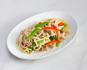 Dish of stir fried bamboo shoots with pork and bell peppers on plate