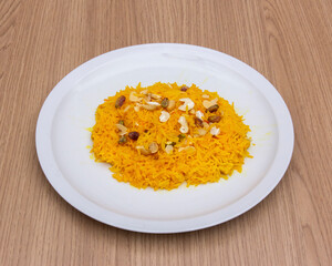Close up of zarda rice with nuts served on a white plate on a table