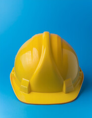 Fototapeta premium Yellow construction helmet of blue background. Happy Labor Day concept.