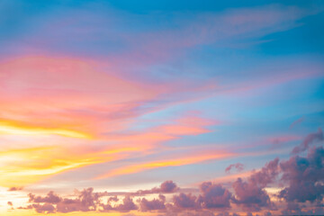 Majestic sunset scene of warm pink and orange clouds scattered across a fading blue sky.