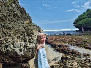 Naklejka premium Cheerful Indonesian Woman in Hijab Enjoying Beach Holiday