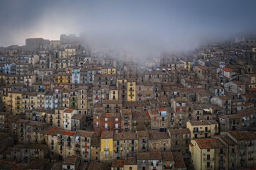 Sunrise view of the rooftops of Gangi with morning fog. Sicily, Italy. August 2024. Aerial drone picture.