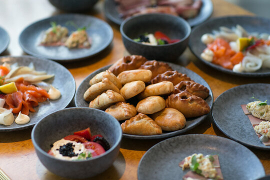 A table that is completely topped with an assortment of plates filled with delicious food and various bowls containing dishes of food