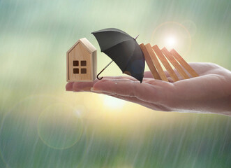 House insurance concept, umbrella protecting against domino fall