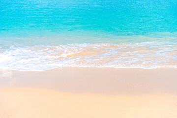 White sand and turquoise sea on a sunny beach day. Idyllic summer holiday background with clear waves.