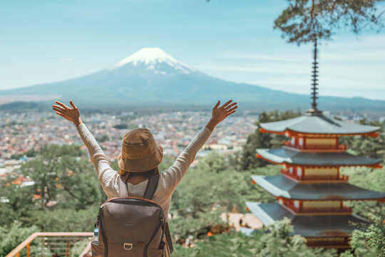 Happy young asian woman traveling in japan during spring at chureito pagoda with mt. fuji background &ndash; scenic and cultural tourism