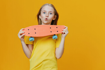 Young girl with a skateboard on a bright yellow background, expressing joy and excitement, wearing...