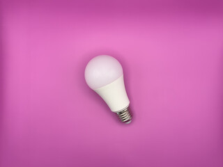 White diode light bulb on purple background without unnecessary objects top view