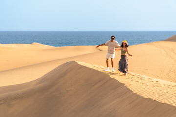 Tourists running down maspalomas dunes in gran canaria, spain