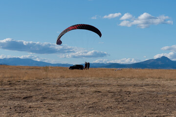 Paragliding adventure in open landscape with mountains and clear blue sky