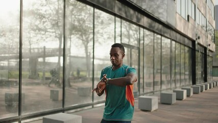 Black man checking fitness performance on smartwatch app running in the city - Powered by Adobe