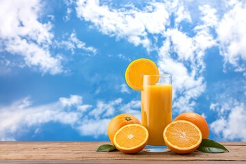Naklejka premium Glass of fresh orange juice on wooden table