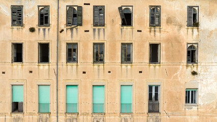 Fototapeta premium Facade of an old abandoned building with broken windows.