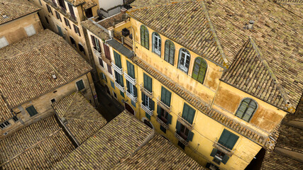 Aerial view of a yellow building in an alley of an Italian village.