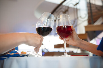 Two individuals are joyfully toasting with their elegant wine glasses at a beautifully set table, celebrating a special moment together
