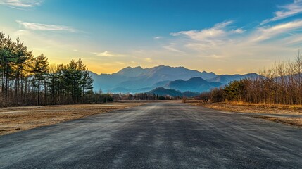 Obraz premium Driving on Asphalt Road Towards Mountains During Golden Hour Scenery