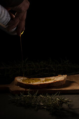 Pouring oil o traditional bruschetta with dark background