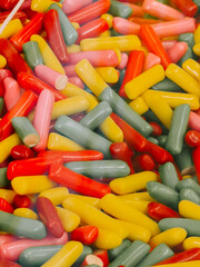 Colorful variety of candy pieces displayed in a glass container at a sweets shop