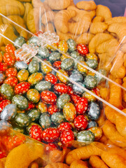 Colorful candies and snacks arranged in a clear container during a festive gathering