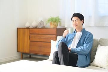 リビングでリラックスする日本人男性
