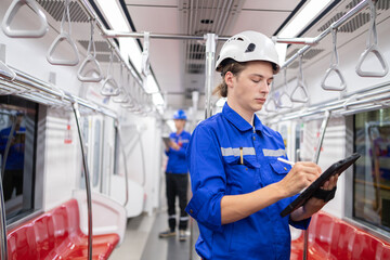 Portrait of young engineer of electric locomotive holding tablet in train