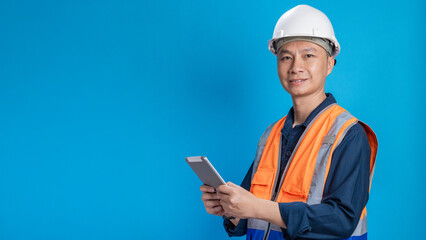 Confident young engineer wearing orange and a safety helmet stands holding a laptop, phone with various emotions.