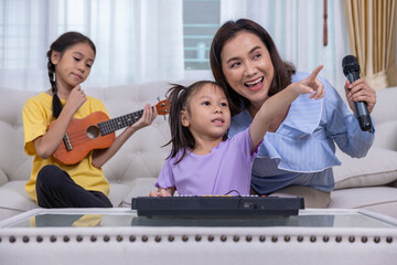 Happy family, mother and daughter are having fun playing music and singing