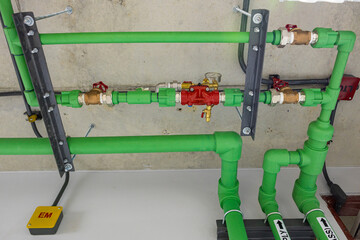 Green industrial pipes with red valve handles