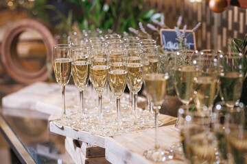 There are numerous elegant glasses of champagne beautifully arranged on the table, adding a festive touch to the atmosphere of the event
