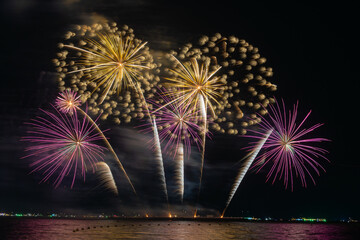 Multicolored Fireworks Exploding Over Water