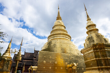 Fototapeta premium Golden pagodas at Thai temple under cloudy sky
