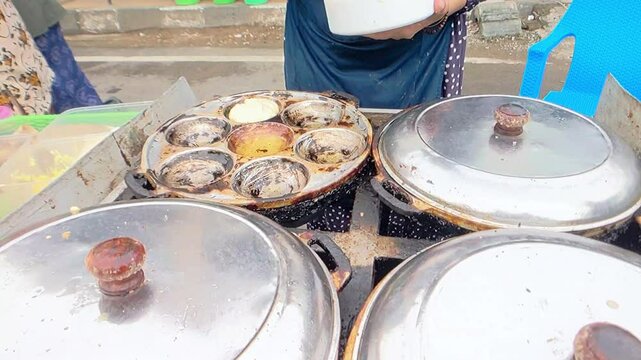 Cinematic shot. The traditional baking process of Samir or Kamir or Khamir pancake on cast iron muffins pan. the cake is made of flour, butter, and egg dough and mostly sold in Pemalang, Central Java,