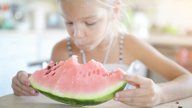Beautiful blonde small girl eating watermelon