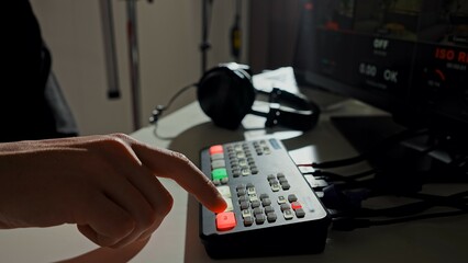 Finger Pressing Button on a Professional Audio Mixer
