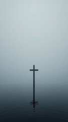 Naklejka premium A cross stands alone on a foggy lake, symbolizing faith.