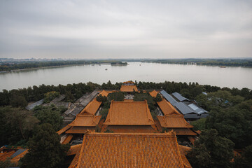 A vast and expansive body of water is beautifully surrounded by lush trees and wellconstructed buildings that enhance the scenery
