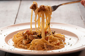 Eating spaghetti with pine nuts, raisin and mushroom