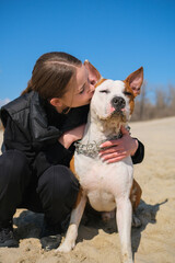 Portrait of cute teenage girl hugging her dog, American Staffordshire Terrier
