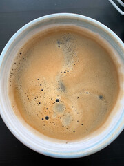 Close-up of a coffee cup filled with dark espresso and a frothy crema.