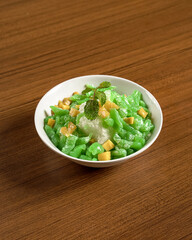 Traditional Indonesian Iced Dessert with Pandan Jelly, Palm Sugar Syrup, and Coconut Milk Served in a Bowl for a Sweet Refreshing Treat. Es Cendol